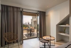 a room with a balcony with a table and chairs at Melian Suites in Nikiti
