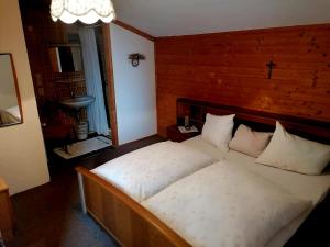 1 dormitorio con 1 cama grande con sábanas y almohadas blancas en Kohlegghof en Schwemmberg