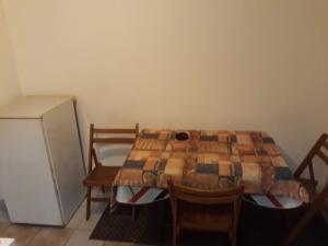 a table and chairs in a room with a table and a refrigerator at Apartmani Gina in Sutomore