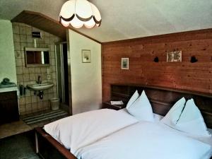 1 dormitorio con cama blanca y lavamanos en Kohlegghof en Schwemmberg