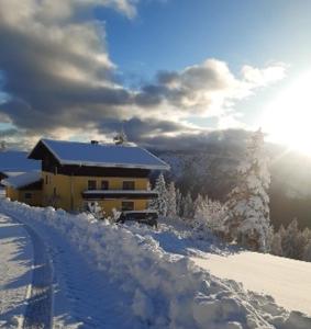 een gebouw bovenop een met sneeuw bedekte berg bij Kohlegghof in Schwemmberg