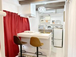 a small kitchen with a sink and two chairs at Ocean Villa Tin Gala - Vacation STAY 98840v in Atsutabaru