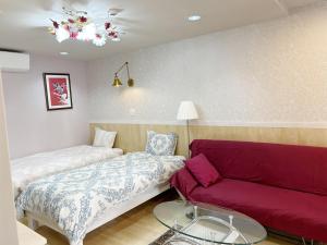a room with two beds and a couch at Ocean Villa Tin Gala - Vacation STAY 98840v in Atsutabaru