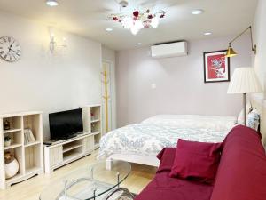 a bedroom with a bed and a tv and a couch at Ocean Villa Tin Gala - Vacation STAY 98840v in Atsutabaru