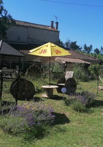 een gele paraplu in een tuin met een tafel bij MES NUITS VINTAGE EN COMBI in Robion en Luberon