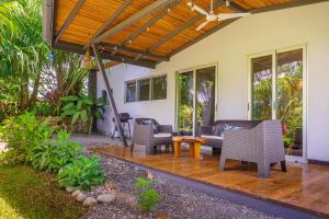 d'une terrasse avec des chaises, un canapé et une table. dans l'établissement Hotel FAREMITI Uvita, à Uvita