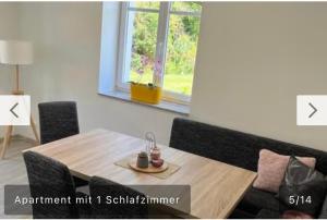 ein Holztisch und Stühle in einem Zimmer mit Fenster in der Unterkunft Ferienwohnung Malisa in Bad Bibra