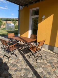 a wooden table and chairs next to a yellow building at Ferienwohnung Malisa in Bad Bibra