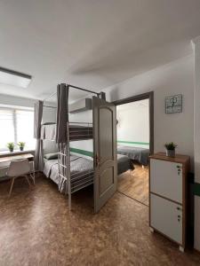 Pokój z 2 łóżkami piętrowymi i drzwiami w obiekcie Хостел Житомир GREEN HOUSE w mieście Żytomierz