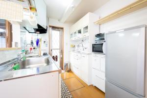 cocina blanca con fregadero y nevera en Hiei Blue Roof - Vacation STAY 13887, en Otsu