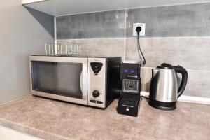 a microwave sitting on a counter next to a coffee maker at Downtown Apartment 10 in Kavála