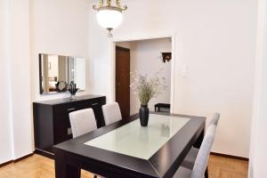 uma sala de jantar com uma mesa preta e cadeiras em Downtown Apartment 10 em Kavala