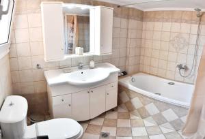 a bathroom with a sink and a toilet and a tub at Downtown Apartment 10 in Kavála