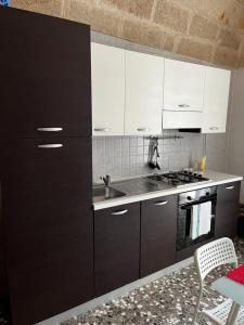 a kitchen with black and white cabinets and a sink at La Dimora di Nonna Lucia in Polignano a Mare