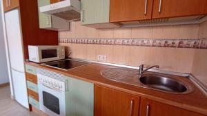 a kitchen with a sink and a microwave at Vacacional Montañés in El Matorral