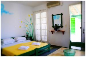 a bedroom with a yellow bed and a window at Georgios Milos in Adamas