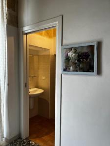 ポリニャーノ・ア・マーレにあるLa Dimora di Nonna Luciaのバスルーム(トイレ付)が備わります。壁に絵画が飾られています。