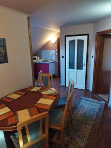 ein Esszimmer mit einem Tisch und Stühlen sowie eine Küche in der Unterkunft Gabi vendégház in Balatonkeresztúr