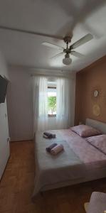 1 dormitorio con 2 camas y ventilador de techo en Two Sisters, en Sveti Filip i Jakov