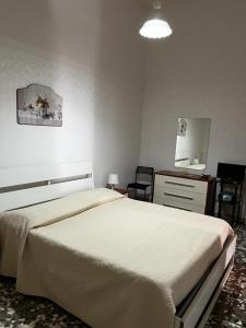 a bedroom with a bed and a dresser and a mirror at La Dimora di Nonna Lucia in Polignano a Mare