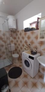 a bathroom with a washing machine and a toilet at Two Sisters in Sveti Filip i Jakov