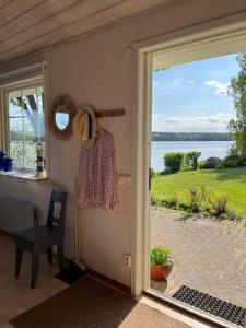 a door leading to a patio with a view of the water at Private lakefront property in Söderköping