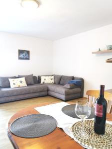 a living room with a couch and a table with a wine glass at Apartmani Gabi in Cesarica