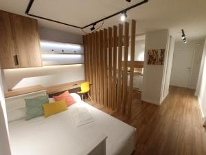 a bedroom with a white bed and a wooden floor at Precioso loft a 600m de la catedral in Santiago de Compostela