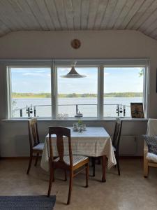 a dining room with a table and a view of the water at Private lakefront property in Söderköping
