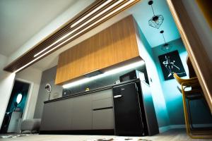 een keuken met een zwarte koelkast en een blauwe muur bij Temali Apartment in Shkodër