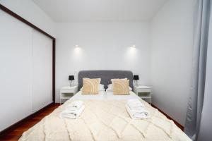 a bedroom with a large bed with two night stands at White Sea - Neptun Park by OneApartments in Gdańsk