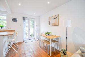Habitación blanca con escritorio y mesa. en Entire House Sleeps 4 Near The River Thames en Maidenhead