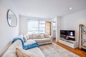 ein Wohnzimmer mit einem Sofa und einem Flachbild-TV in der Unterkunft Entire House Sleeps 4 Near The River Thames in Maidenhead