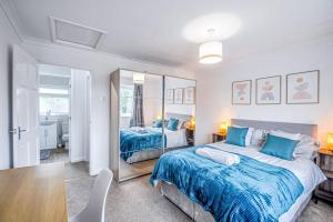 1 Schlafzimmer mit 2 Betten und einem Spiegel in der Unterkunft Entire House Sleeps 4 Near The River Thames in Maidenhead