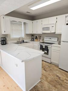 a kitchen with white cabinets and white appliances at Close to the beach and attractions! Perfect for families or traveling nurses! in Wilmington