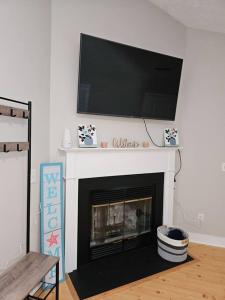 a living room with a fireplace with a flat screen tv above it at Close to the beach and attractions! Perfect for families or traveling nurses! in Wilmington