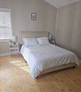 a white bedroom with a bed and a wooden floor at Close to the beach and attractions! Perfect for families or traveling nurses! in Wilmington +10 photos