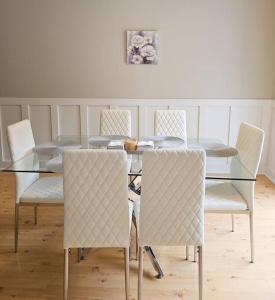 - une table à manger en verre avec des chaises blanches, une table en verre et une chaise longue dans l'établissement Close to the beach and attractions! Perfect for families or traveling nurses!, à Wilmington