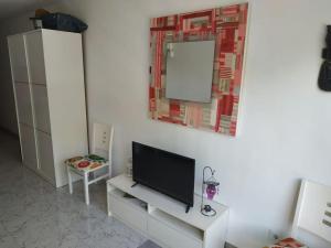 ein Wohnzimmer mit einem TV und einem Spiegel in der Unterkunft Apartment in Salou. Beach Relax HUTT-033474-91 in Salou