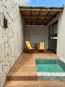 a patio with a pool and a table and chairs at Lotus Patacho in Pôrto de Pedras