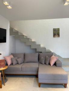 a living room with a couch and a staircase at Lotus Patacho in Pôrto de Pedras