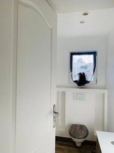 a bathroom with a toilet and a tv on a wall at Jolie Appartement Rez de jardin in Pégomas