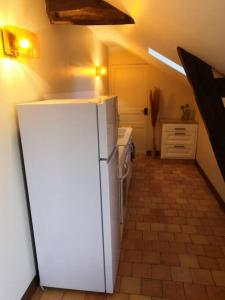 a kitchen with a white refrigerator in a room at Studio proche zoo de la Flèche in La Flèche