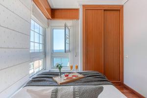 a room with a bed with a tray of food on it at San Amaro Beach 2 by TheBlueWaveApartmets com in A Coruña