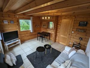 柯盧塞爾的住宿－Le Ptit Beccon，小木屋的客厅配有沙发和桌子