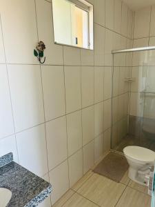 a bathroom with a toilet and a glass shower at Pousada DDB in Resende Costa +33 photos