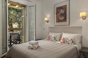 1 dormitorio con 1 cama con toallas en Iro Suites en Andros