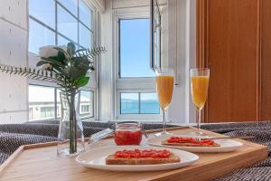 a table with two plates of food and two glasses of champagne at San Amaro Beach 2 by TheBlueWaveApartmets com in A Coruña