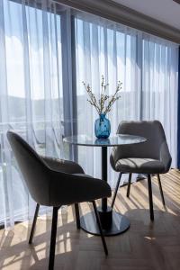 Duas cadeiras e uma mesa num quarto com uma janela em Oban Apartments em Oban