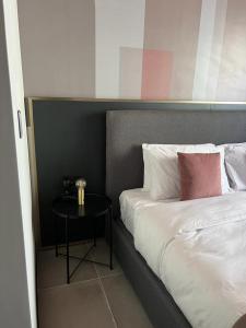 a bedroom with a bed with a table next to it at Eleven by Warren Collection in Sliema